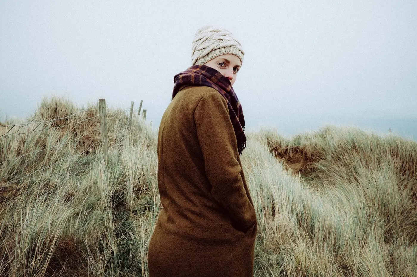 Femme en manteau camel dans les dunes
